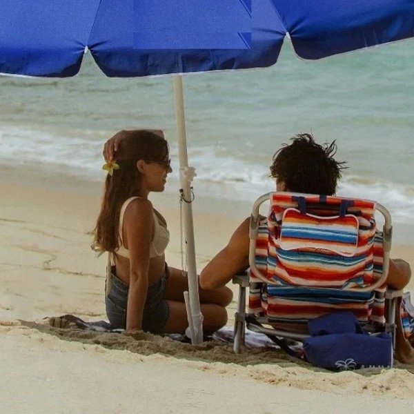 Couple relaxing under a Palapa Aruba beach umbrella rental in Aruba