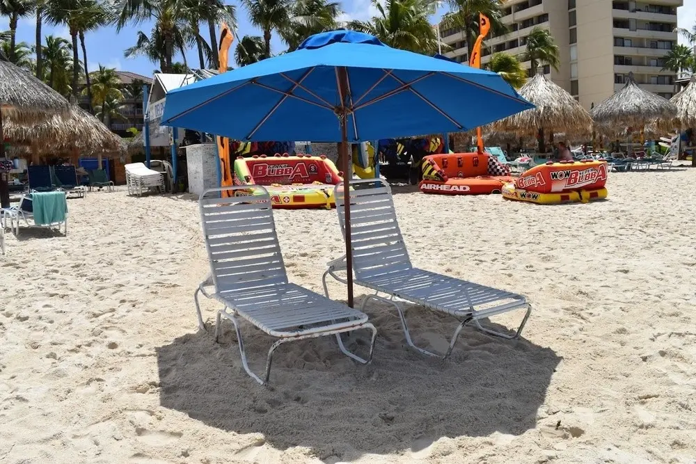 Beach umbrella and two chairs package set up on the sand in Aruba